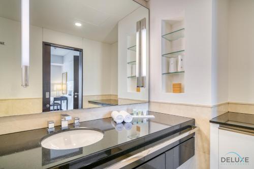 y baño con lavabo y espejo. en Pristine 1BR in The Address Residences Dubai Marina by Deluxe Holiday Homes en Dubái
