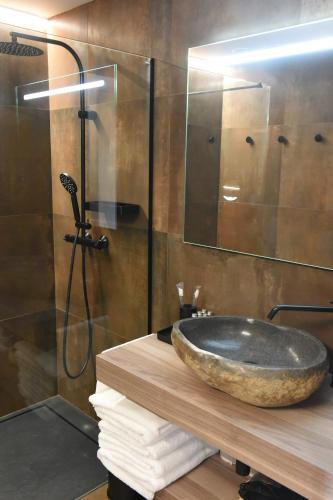 a bathroom with a stone sink and a shower at Era del Rafel in Escaldes-Engordany