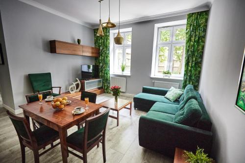 ホジュフにあるZielony Apartament DE LUX dla 4 osób Chorzów Katowiceのリビングルーム(緑のソファ、テーブル付)