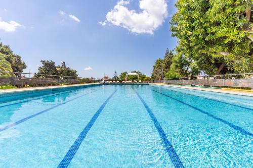 a large swimming pool with blue water at Albergue Inturjoven Marbella in Marbella