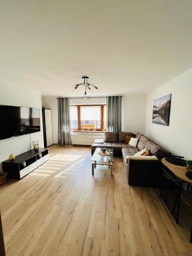 a living room with a couch and a flat screen tv at Apartament Kolejowa 7 in Nowy Targ