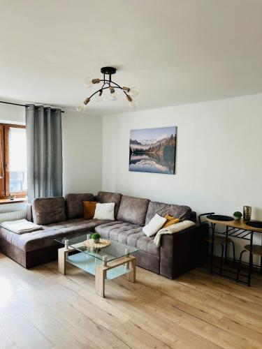 a living room with a couch and a table at Apartament Kolejowa 7 in Nowy Targ