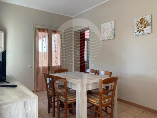 a dining room with a table and chairs at Villa Camelia in Torre Lapillo