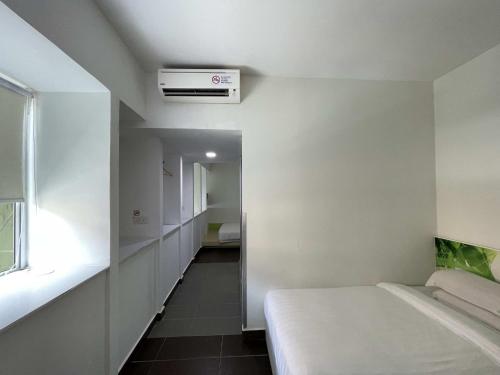 ein weißes Zimmer mit einem Bett und einem Fenster in der Unterkunft Green Apple Boutique Hotel in Kota Kinabalu