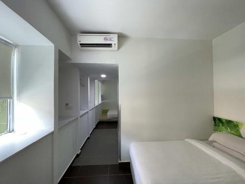 a white room with a bed and a window at Green Apple Boutique Hotel in Kota Kinabalu