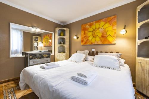 ein Schlafzimmer mit einem großen weißen Bett mit Handtüchern darauf in der Unterkunft Bonito y acogedor apartamento con terraza in Los Realejos