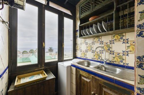 kuchnia ze zlewem i oknem w obiekcie Bonito y acogedor apartamento con terraza w mieście Los Realejos