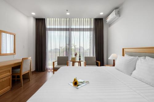 a hotel room with a large bed and a desk at Sunflower International Village in Hai Phong