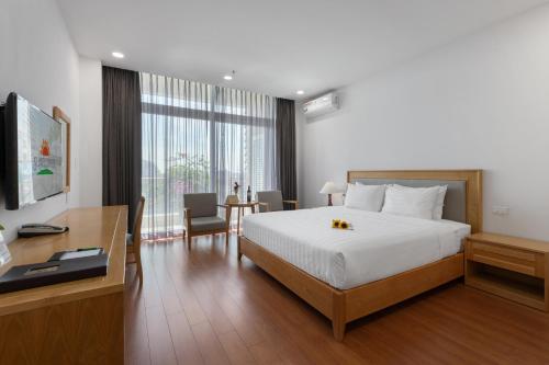 um quarto de hotel com uma cama e uma secretária e um quarto em Sunflower International Village em Haiphong