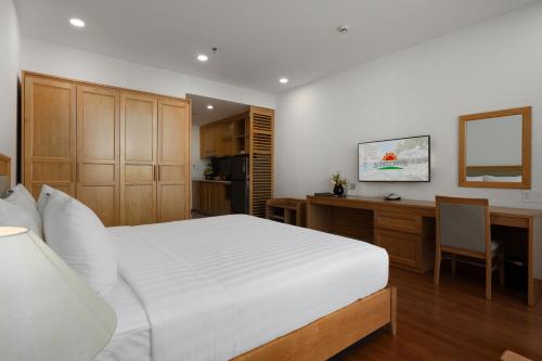 a bedroom with a large white bed and a desk at Sunflower International Village in Hai Phong