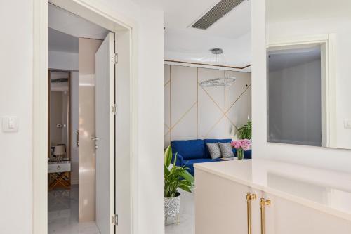 ティヴァトにあるModerna Luxury Apartments with HEATED poolの白いキャビネットと青いソファ付きのキッチンが備わります。