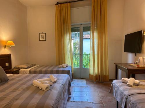 a hotel room with two beds and a window at Le Focette dell'Orso in Scanno