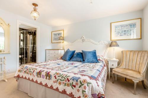 a bedroom with a bed with blue pillows and a chair at Armando in Truro