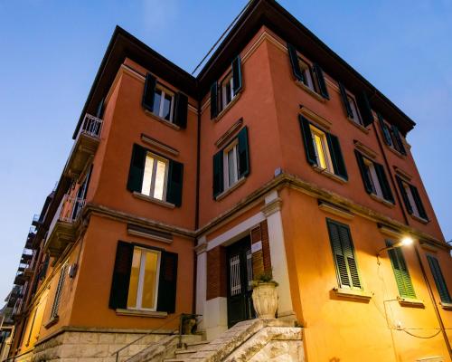 a large orange building with black shuttered windows at Essential Rooms in Campobasso