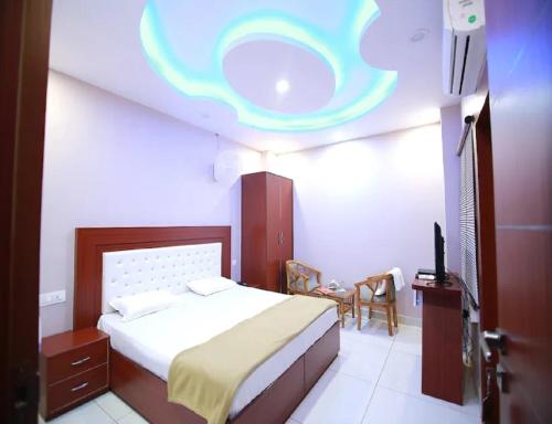 a bedroom with a bed and a ceiling with a cloud at Hotel Kings, Rohtak in Rohtak
