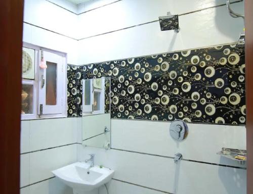 a bathroom with a sink and a black and white wall at Hotel Kings, Rohtak in Rohtak