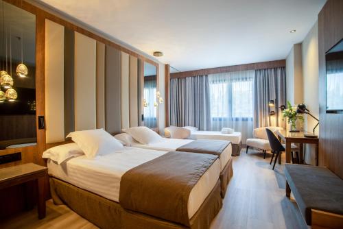 Habitación de hotel con cama grande y sala de estar. en Hotel Granada Center, en Granada