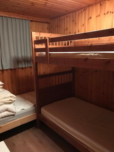 Chalet op rustig vakantiepark في Heure: غرفة بسرير بطابقين مع سريرين في كابينة