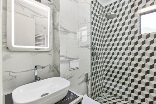 a white bathroom with a sink and a mirror at Moderna Luxury Apartments with HEATED pool in Tivat