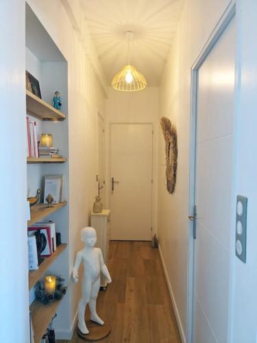 un couloir avec une statue de chien blanc dans une chambre dans l'établissement Appartement L'idéal hyper centre-ville, à Charleville-Mézières