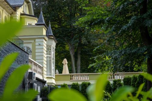 a white house with a balcony and a tree at Villatoro in Zgorzelec