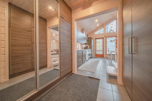 a kitchen with wooden walls and glass doors at Levillas Koutakaari 2B in Levi