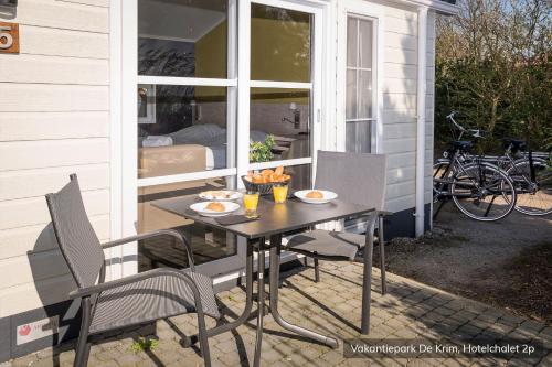 a table and chairs on the porch of a house at Vakantiepark De Krim Texel in De Cocksdorp