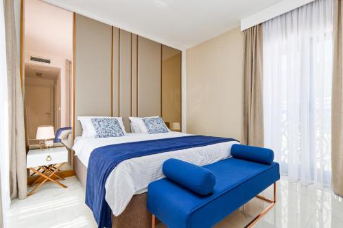 a bedroom with a large bed and a blue chair at Moderna Luxury Apartments with HEATED pool in Tivat