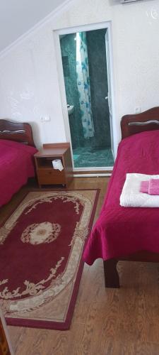 a bedroom with two beds and a large window at Nona Guest House in Shilda