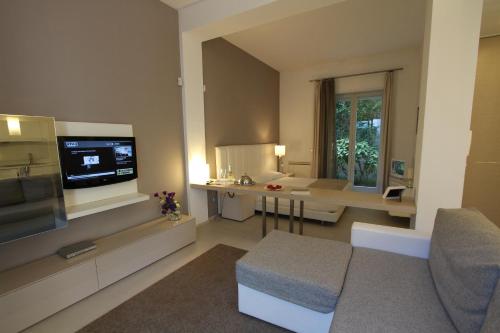 a living room with a tv and a couch and a table at Soglow Business Class Hotel in Molfetta