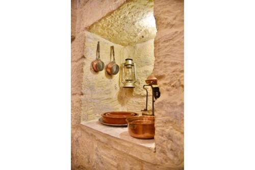 a kitchen in a stone wall with pots and pans at Ta'Martin Farmhouse Xewkija Gozo in Xewkija