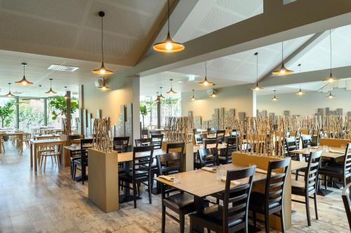 a dining room with wooden tables and chairs at Terme Olimia - Hotel Breza in Podčetrtek