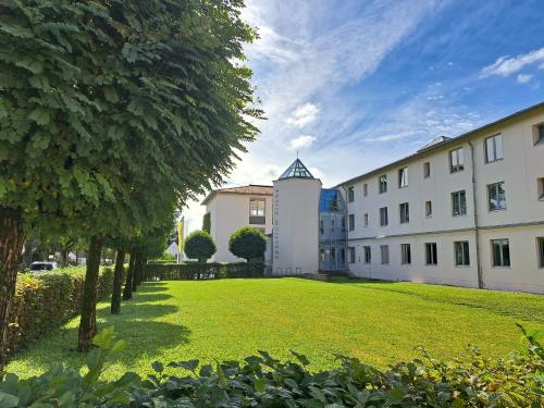 ein großer Rasenplatz vor einem Gebäude in der Unterkunft Spectrum Kirche Exerzitien-und Bildungshaus auf Mariahilf in Passau