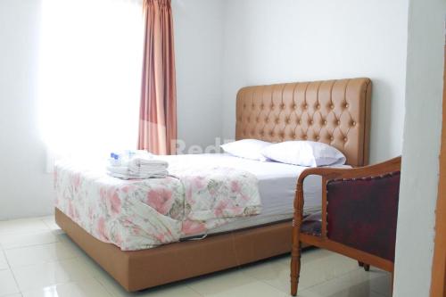 a bedroom with a bed and a window at Brahma Hotel Mitra RedDoorz in Jakarta