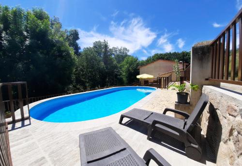 a swimming pool with a chair and a table at Apartamentos rurales Alameda del Jerte in El Torno