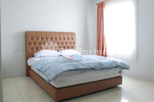a bed in a bedroom with a large window at Brahma Hotel Mitra RedDoorz in Jakarta