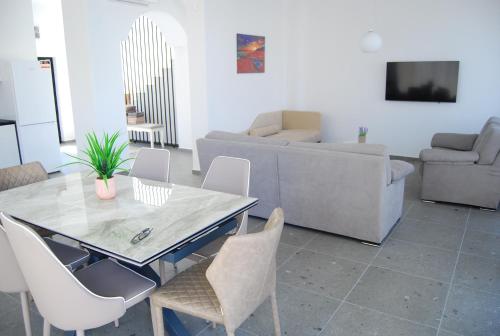 a living room with a table and chairs and a couch at Coral Luxury Villas in Lozenets