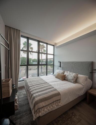 a bedroom with a large bed with a large window at Apartamentos Rosa Velázquez in Mérida