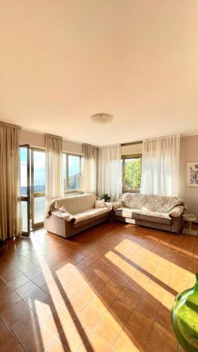 a large living room with two beds and windows at Beatrice Apartment Crocello in Montignoso