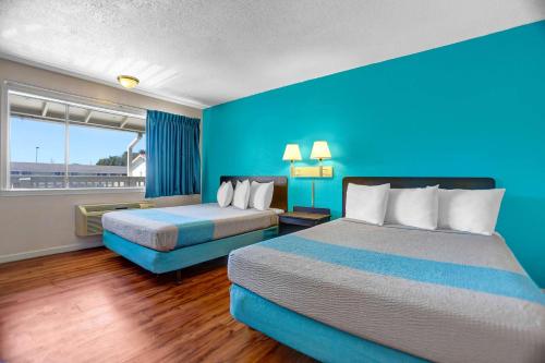 Habitación de hotel con 2 camas y pared azul en Motel 6-Fort Bragg, CA, en Fort Bragg