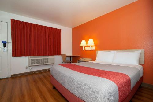 a hotel room with a bed and a red window at Motel 6-Palm Springs, CA - East - Palm Canyon in Palm Springs