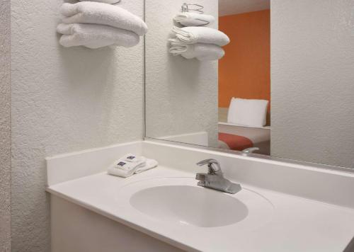 a bathroom with a sink and a mirror and towels at Motel 6-Buena Park, CA - Knotts Berry Farm - Disneyland in Buena Park