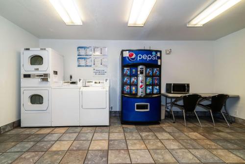 uma máquina de refrigerante num quarto com uma mesa e cadeiras em Motel 6-Palm Springs, CA - East - Palm Canyon em Palm Springs