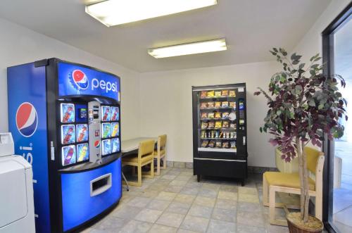 a pepsi machine in a room with a table and chairs at Motel 6-Palm Springs, CA - East - Palm Canyon in Palm Springs