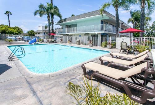 a swimming pool with lounge chairs and a house at Motel 6-Rosemead, CA - Los Angeles in Rosemead