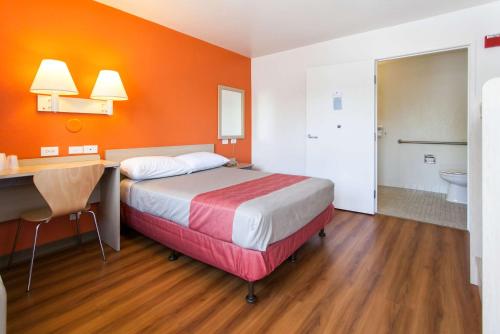 a bedroom with a bed and a desk and a bathroom at Motel 6-Rosemead, CA - Los Angeles in Rosemead