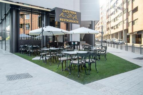 a group of tables and chairs with umbrellas on a sidewalk at Hotel Granada Center in Granada