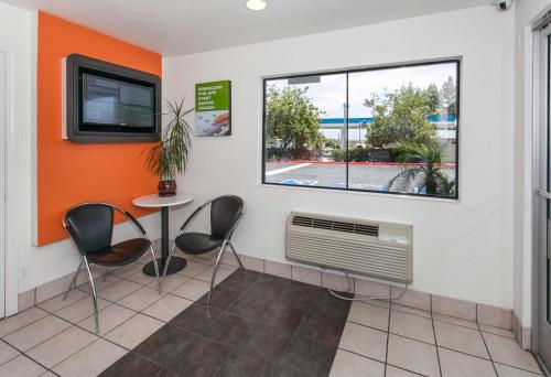 a waiting room with a table and chairs and a window at Motel 6-Rosemead, CA - Los Angeles in Rosemead