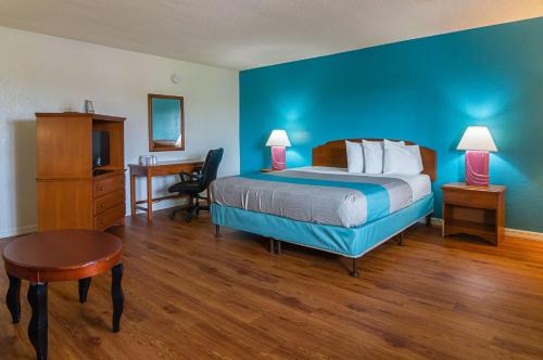 Habitación de hotel con cama, escritorio y silla en Motel 6-Ocala, FL - Conference Center, en Ocala Ridge