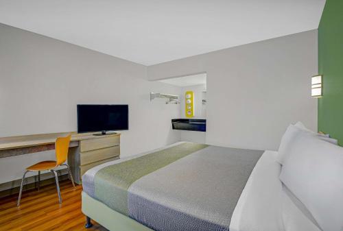 a bedroom with a bed and a desk with a television at Motel 6-Tallahassee, FL - Downtown in Tallahassee